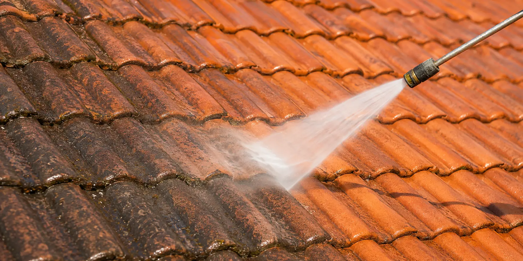 Pressure washing moss and dirt from roof tiles